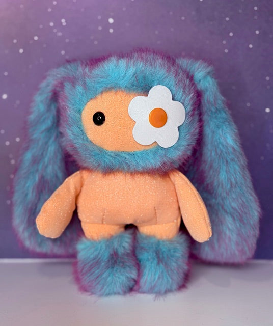 Blue plush bunny bag charm with orange belly and white flower patch