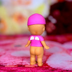 Back view pink mini figurine wearing purple shirt with white face designs