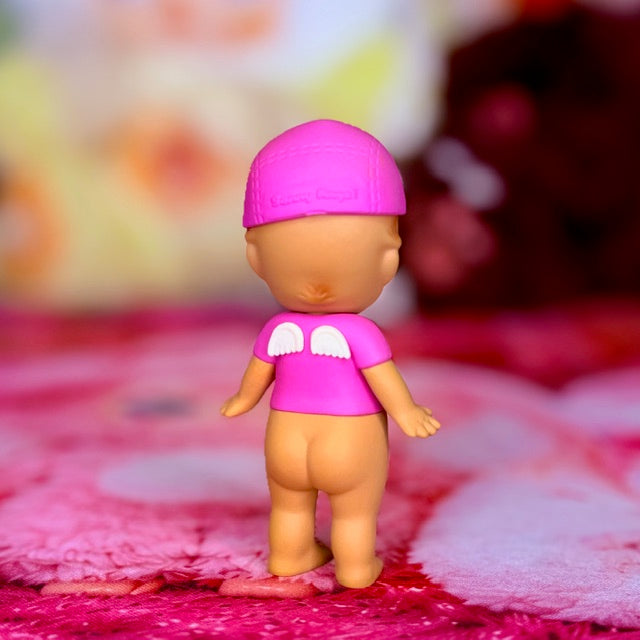 Back view pink mini figurine wearing purple shirt with white face designs