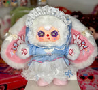 Plush baby figure in blue dress with white lace bonnet, pearl belt, fluffy pink-and-white arms