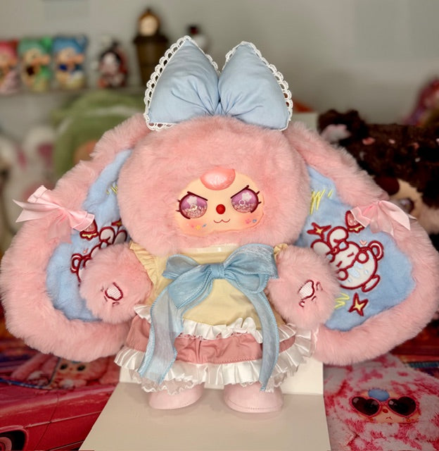 Pink and light blue plush figure in sailor-style dress with big bow and side arms