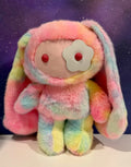 Pastel rainbow plush bunny with patchy smiling face and red button eyes
