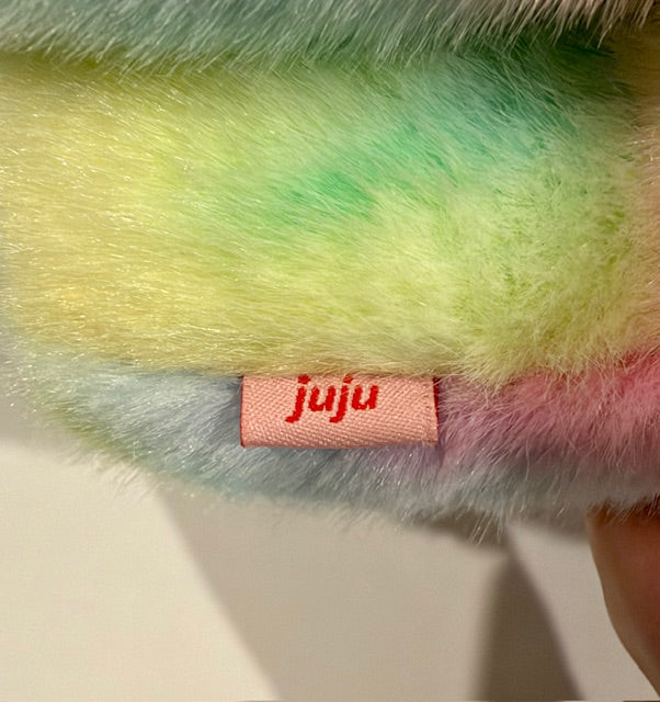 Pastel rainbow plush bunny, close-up of “Juju” fabric tag