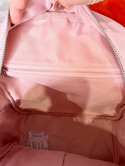 Kids backpack interior with pink lining and visible care label at bottom