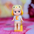 Lop-eared rabbit figurine with blue shirt, orange print, standing on yellow base