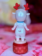 Light blue glitter reindeer figurine with red antlers, standing on a red round base