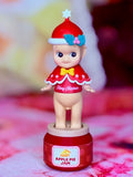 Sonny Angel Christmas Santa figure with blue flower hair clip; red base labeled "Apple Pie Jam"