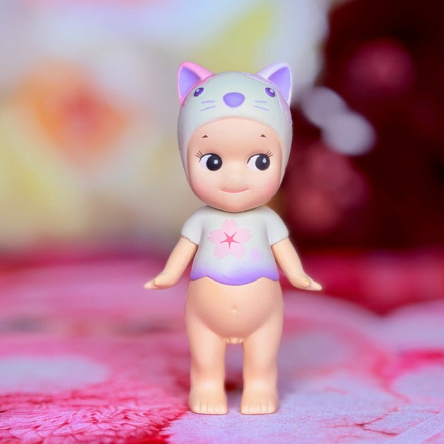 Sonny Angel cat figurine front view, white suit with purple face accents and pink star