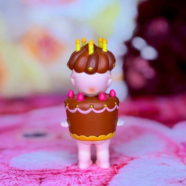 Sonny Angel birthday cake figurine with candles and chocolate topper, pink feet