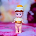 Small Sonny Angel figurine facing forward, orange slice hat and white ruffle outfit