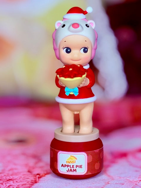 Pink character holding red apple pie jam on red label base