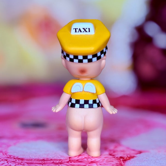 Yellow taxi-themed vinyl figure with 'TAXI' cap and checkered outfit