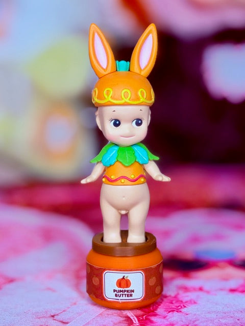 Sonny Angel Easter Bunny figurine, orange bunny hat, green outfit, base labeled Pumpkin Butter