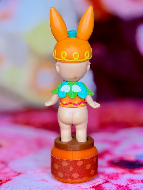 Sonny Angel Easter Bunny figurine, orange bunny hat, green outfit, round base