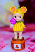 Yellow mouse figurine with pumpkin dress, holding purple lollipop; base shows Pumpkin Butter label.