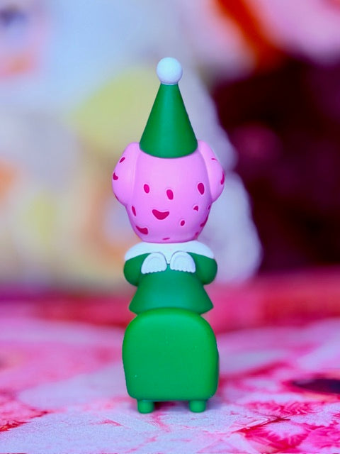 Santa helper figurine with purple hat and green outfit, standing with white cuffs
