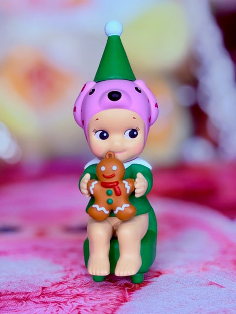 Dalmation Santa’s Little Helper figurine in green suit, holding a gingerbread cookie
