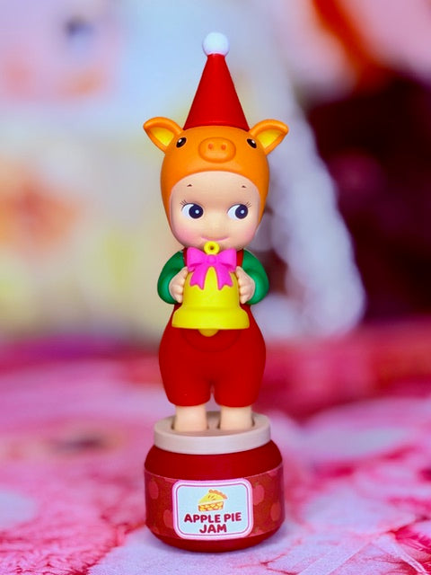 Pig Santa’s Little Helper figurine with pink apron, standing on Apple Pie Jam base