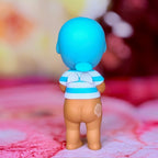 Manatee-style toy figure with bright blue head, white-and-blue swim top, tan body