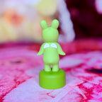 Green rabbit vinyl mini figure with white belly and raised arms
