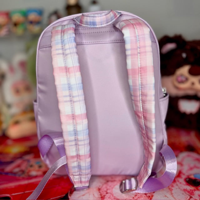 Lavender kids backpack with pink-and-blue plaid back panel and adjustable straps