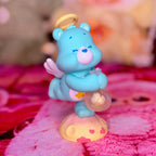 Wish Bear figurine with a star halo, tiny wings, and a clear orb on a heart-patterned base