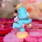 Side view of the blue Wish Bear figurine holding a clear orb above a heart-patterned base
