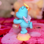 Rear view of the Wish Bear figurine showing its wings, halo, and raised foot